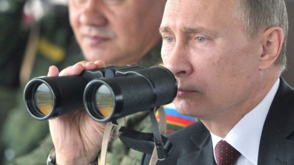 Russian president Vladimir Putin (R) and defence minister Sergei Shoigu (L) inspect military exercises in the Pacific Ocean near the Sakhalin island on 16 July 2013