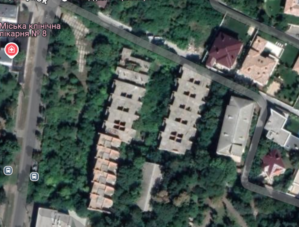 Вид зі спутника на недобудовані будинки посеред зеленої зони
